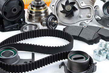 Auto parts background. Hub, pump, brake pads, filter, timing belt, rollers, constant velocity joints, thermostat and other on white background. Set of spare parts for repair