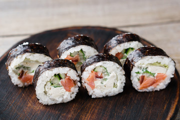 Japanese sushi on wooden plate, food background