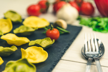 Classic ravioli filled with basilico and cheese on a platter of stone.
