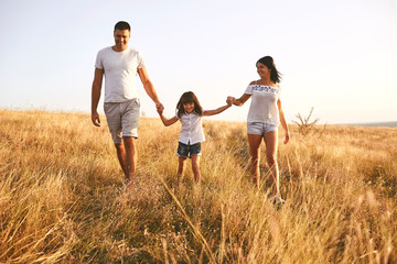 Fototapeta premium Happy family playing on nature in summer at sunset.