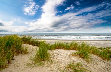 Dune beach on the North Sea island Langeoog in Germany with clouds on a beautiful summer day,...