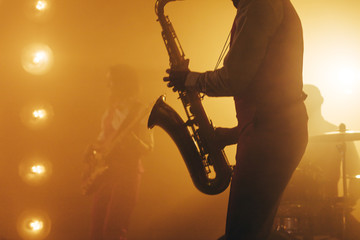 musician hlding a saxophone. melody instrument. popular music
