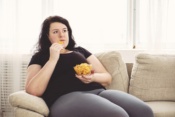 lack of physical activity, sedentariness, imbalanced nutrition, laziness, homebody. fat woman overeating junk food