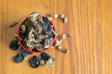 dried mushrooms boletus sliced, on a plate, on an old wooden background. Composition of dried mushrooms and plate on wooden background. copy space.