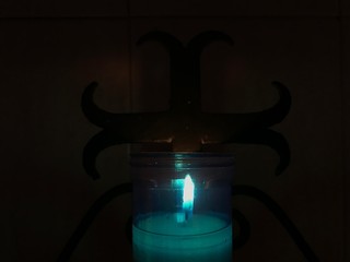 Blue lighting candle in pedestal of church in Holy Week