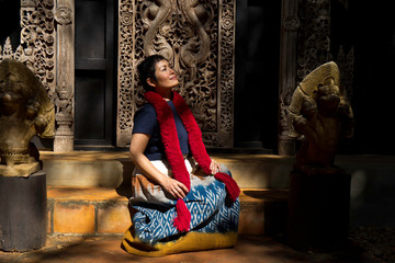 Femme et boiserie sculptées au black temple de Chiang Raï