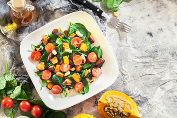 Roasted pumpkin salad with spinach, tomatoes and nuts