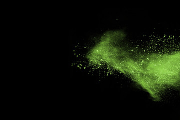The movement of abstract dust explosion frozen green on black background. Stop the movement of powdered green on black background. Explosive powder green on black background.