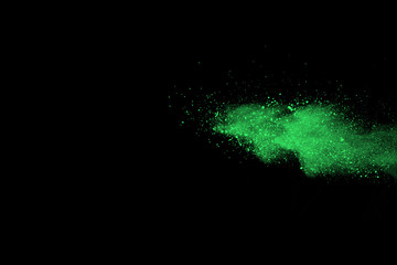 Fototapeta na wymiar The movement of abstract dust explosion frozen green on black background. Stop the movement of powdered green on black background. Explosive powder green on black background.