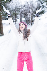 Beautiful woman is playing with snow.