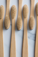 Wooden bamboo toothbrushs on a marble background