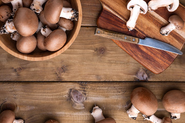 Champignon mushrooms, sacking mat and spices on wooden background. Wooden dishes. Photo in a rustic style. Place for text. The concept of a village photo.