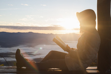 Young woman praying With the Holy Bible  in the morning, Woman praying with hands together on the...