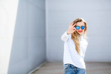 Shapely young woman with long hair dancing outdoor relaxing with smile and eyes closed. Portrait of chilling blonde girl