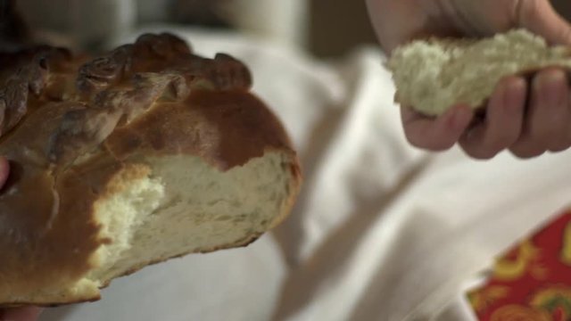 girl breaks a piece of loaf bread