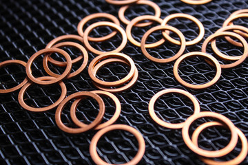 copper washers on black metal mesh background