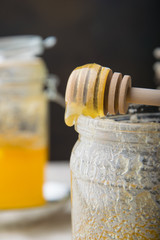 Fototapeta na wymiar spoon with honey bee on a glass jar