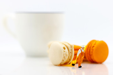 Miniature people: business team sitting on cup of coffee with morning news. Coffee time of business concept.
