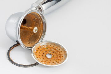 Broken shower head with limescale and rust on it