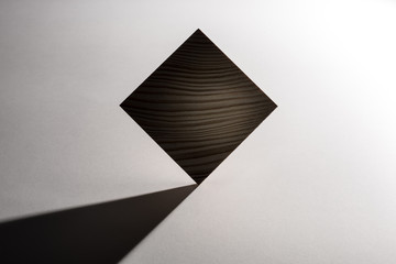 Abstract geometric real wooden cube whit real shadow on white background and it's not 3D render. Lighting technique.