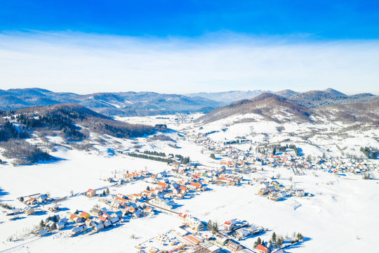     Croatian countryside landscape in winter, panoramic view of small town of Mrkopalj under snow in Gorski kotar, mountains in background 