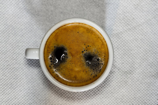 Cup of Espresso coffee on white napkin, espresso creme.