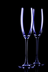 Two empty glasses backlit, on a black background. 