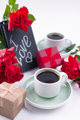 A bouquet of red roses and fresh aromatic tea for a romantic breakfast. Flowers and a letter as a gift. Valentine's day and mother's day concept. Flat lay. Copy space,