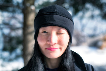 Chinese woman winking wintertime outside