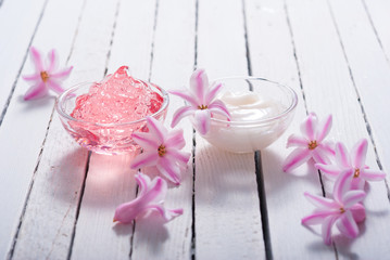 beauty products with hyacinth flowers on white wood
