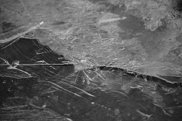 Broken ice surface on black background, winter closeup
