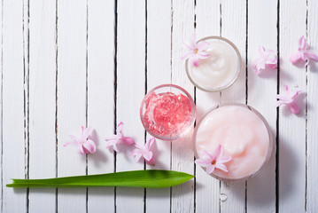 beauty products with hyacinth flowers on white wood