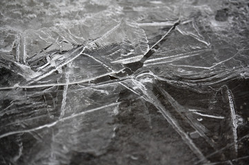 Broken ice surface on asphalt, winter closeup