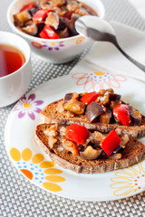 Vegetable stew with eggplant, red pepper and tomatoes on toasted rye bread