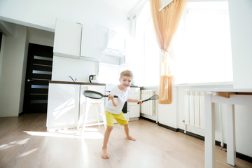 funny European little boy chef dancing,Happy weekend, boy wants to make pancakes, but the frying pan are too gay, he decided to have fun holding wooden spoons in his hands, having fun while cooking