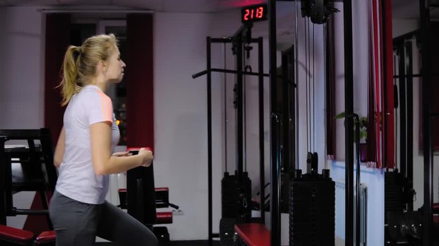Adduction or abductor machine - Attractive girl exercising her thighs in the gym