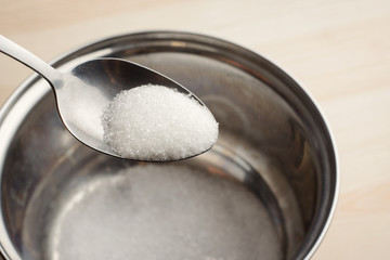 Fototapeta na wymiar Adding sugar to the bowl. Cooking dishes with sugar