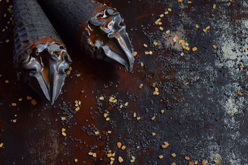 Black ice cream with sesame and caramel in black waffle ice cream cones. Copy space. Trendy summer food