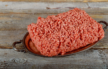 Minced raw ground beef on old wood background.