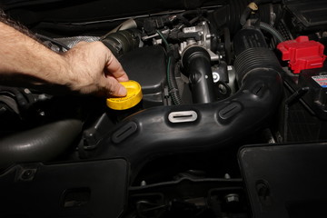 Meccanico controllo olio motore auto in officina riparazione