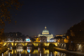 Rome night skyline with Vatican St Peter Basilica and St Angelo Bridge crossing Tiber River in the city center of Rome, Italy. It is historic landmark of the Ancient Rome and travel destination.