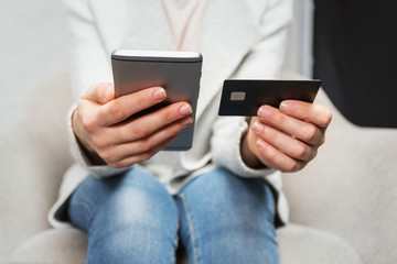 Lady using plastic card and telephone for shopping