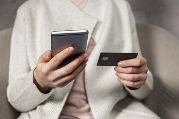 Woman making shopping online using plastic card and cellular