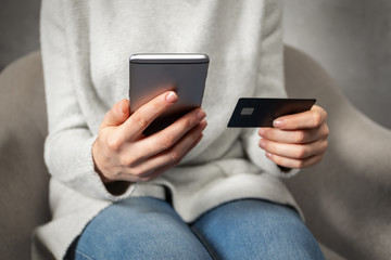 Woman holding plastic card and cellular, she making shopping online