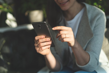 Woman holding cellular in her hands and pointing on display