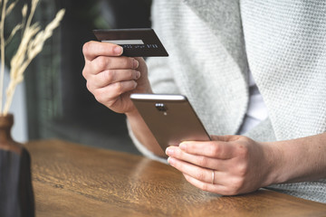 Lady holding cellular and plastic card in her hands