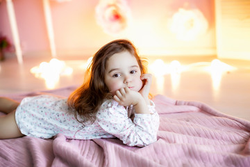 Adorable little girl dressed as a ballerina in a tutu, tying her ballet slippers. © ElenaBatkova