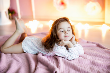 Adorable little girl dressed as a ballerina in a tutu, tying her ballet slippers. © ElenaBatkova