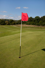 Obraz premium Red Flag on a Golf Course marking the hole