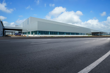 Fototapeta na wymiar Road asphalt pavement and modern factory warehouse..